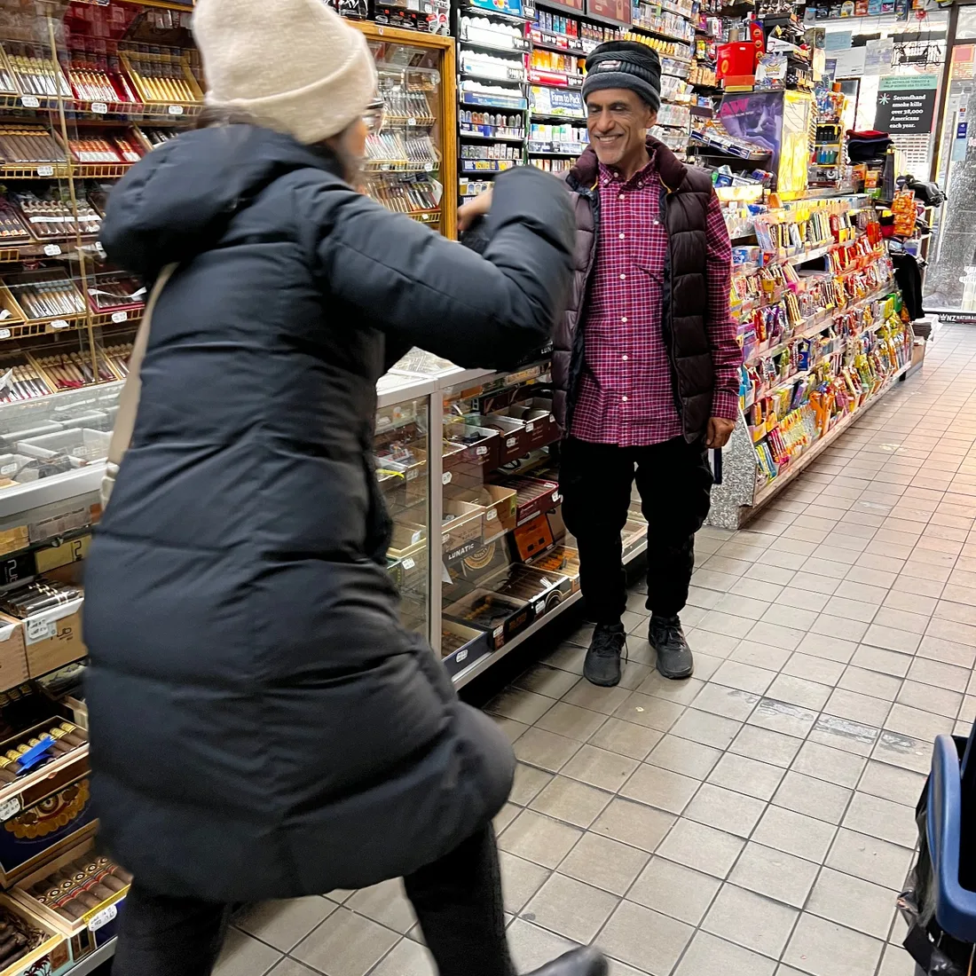 Gulce Kilkis photographing tabby cat by beverage fridges